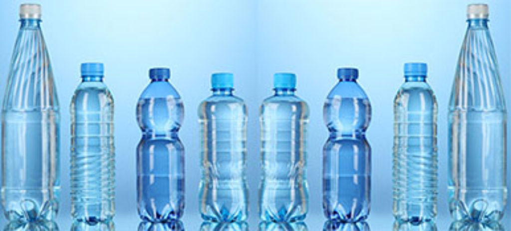 Vor hellblauem Hintergrund stehen 8 Wasserflaschen unterschiedlicher Größe. Die beiden äußeren, größten, haben weiße Deckel, die sechs Flaschen in der Mitte dunkel- oder hellblaue Deckel.