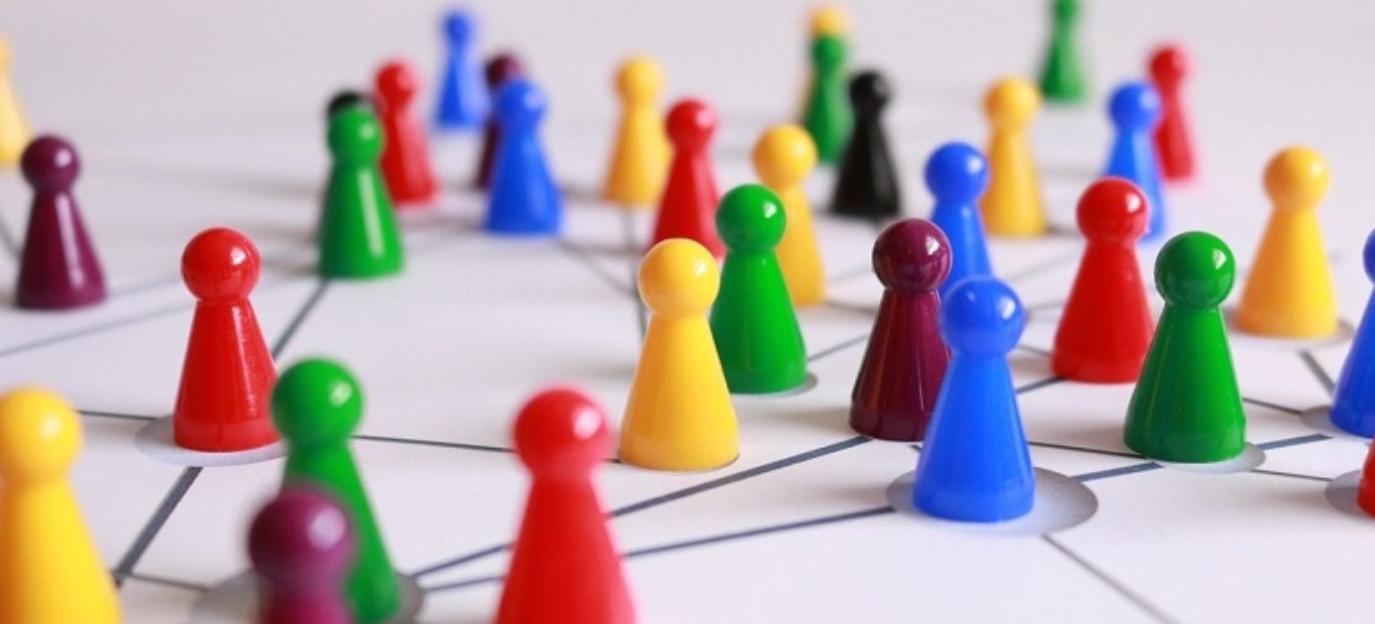 Viele bunte Spielfiguren auf einem Spielfeld.