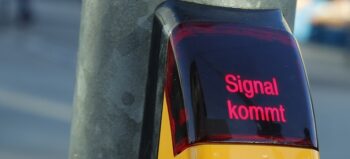 Display auf Signalkästchen an Ampel mit rotem Schriftzug "Signal kommt".