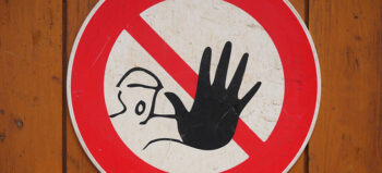 rot umrandetes Gefahrenschild mit einer ausgestreckten Hand.