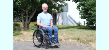 Rollstuhlfahrer Bruno Janßen in Jeans und hellblauem Hemd im Garten der Manfred-Sauer-Stiftung.