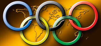 Olympische Ringe vor Weltkarte.