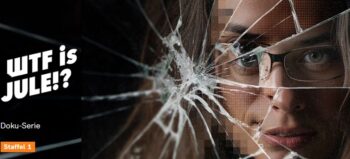 Frauengesicht mit Brille hinter gesprungener Glasscheibe.