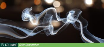 Blauer dünner Rauch vor dunklem Hintergrund.