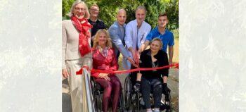 Team der Werner Wicker Klinik durchschneidet rotes Band zur Eröffnung des Rollstuhlparcours. Mit auf dem Bild zwei Frauen im Rollstuhl und Karola Schwarz (links), Leiterin der Manfred-Sauer-Stiftung